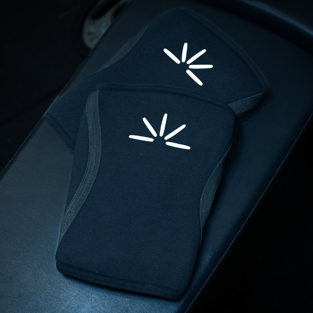 Sorte Trackfie knee sleeves ligger på en bænk